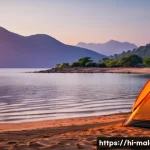 말라위에서 텐트 캠핑하기 - **Serene Sunrise over Lake Malawi Camping:**
A breathtaking wide shot capturing a vibrant sunris...